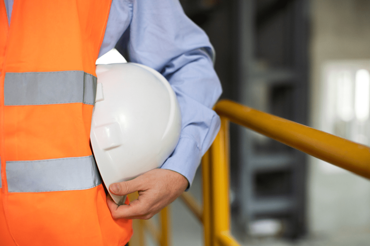 um segurança do trabalho, segurando um capacete